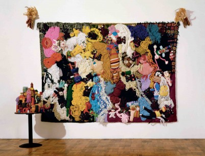 Mike Kelley  More Love Hours Than Can Ever Be Repaid (1987), Handmade craft items and afghans sewn onto canvas, 244 x 323 x 15 cm. (foreground: 1987 The Wages of Sin; Wax candles on wood),