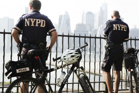 Bicycle police, bank East River, Manhattan behind © William Klein