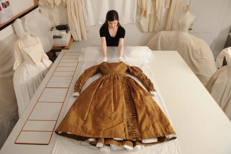 Conservators working on Queen Victoria's Privy Council Dress, on display in 'Victoria Revealed'