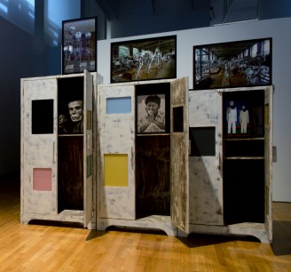 Atul Dodiya, (b.1959 Mumbai, India) Three Brothers, 2012–13. An installation with 3 treated wooden cabinets glass, enamel paint, framed photographs, cloth, iron hanger & iron crutches. Photo by Hai Zhang Courtesy of the Queens Museum of Art