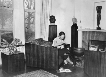 Dora Gordine by the fireplace at Dorich House