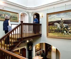 Hallway and landing at Castle House showing a painting of Violet, Lady Munnings on horseback on Exmoor (1924)