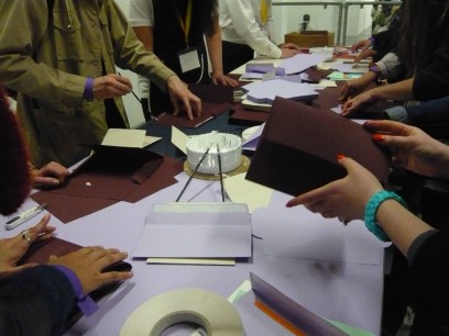 Visitors to the show try their hand at making envelopes. A skilled maker can make 300 an hour, perfectly!