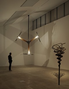 Conrad Shawcross, installation view at Turner Contemporary. Projections of the Perfect Third 2011, left to right: Limit of Everything (5:4) 2011, metal, oak, mechanical system, light dimensions variable; Harmonic Manifold 1 (5:4) 2011, cast bronze, 225 x