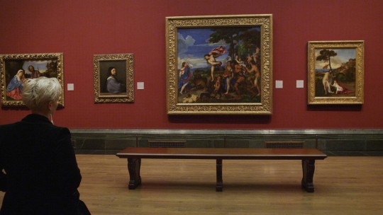 Film still. A visitor explores the Gallery's collection of Titians