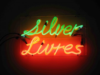 Bruce Nauman. Silver Livres. 1974. Neon tubing with clear glass tubing suspension frame. 30.2×49.7×7 cm. Collection Ealan and Melinda Wingate © 2013 Bruce Nauman/Artists Rights Society, New York