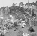 The Liberation of Bergen-Belsen Concentration Camp, April 1945. Women inmates prepare food in the open air, using the boots of the dead (piled up in the background) as fuel for their fires.